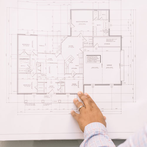 hand examining a house blueprint