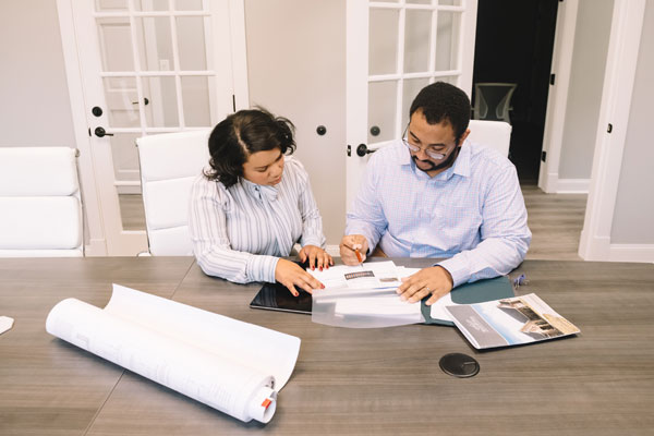 two people reviewing construction documents at a desk