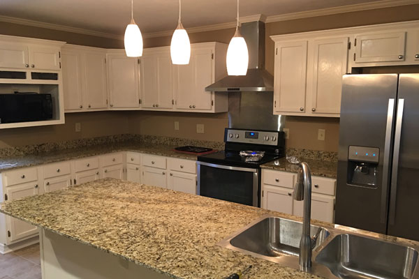 newly renovated kitchen with stainless steel appliances and white cupboards